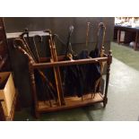 Edwardian period long oak umbrella/stick holder (lacking tray base), holding nine assorted walking