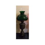 Victorian cast metal lamp on a black glass circular base with green shade, 22ins tall