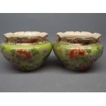 Pair of squat jardini res with a gilt and floral design on a green background with a fluted top (a/