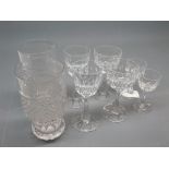 Pair of facetted cut glass beakers together with a set of six clear glass wine glasses in varying
