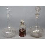 Two clear glass decanters, one with a facetted stem and stopper, the other with etched floral