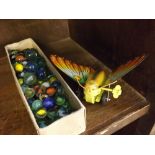 Small box of mixed glass marbles together with a tin plate Chinese made butterfly (2)