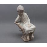 Lladro model of a young boy in his nightgown sitting on a tree trunk, 9ins tall