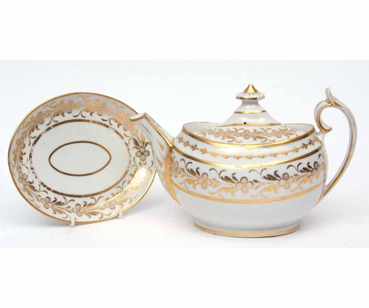 Early 19th century London shape teapot and cover with matching base decorated in gilt with a