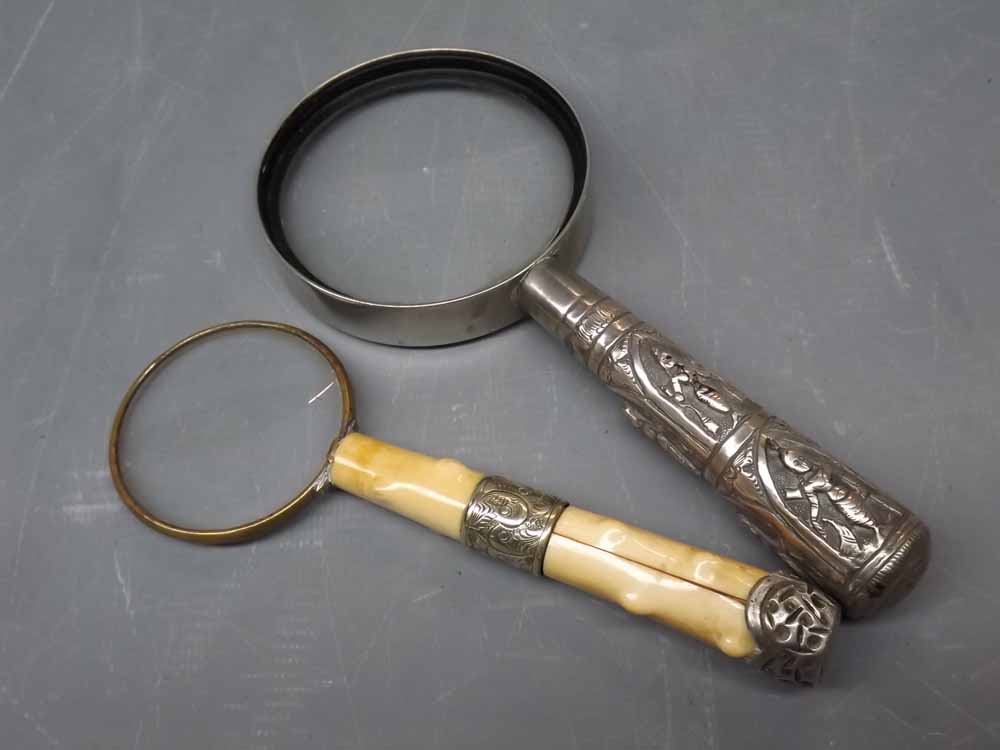 Two magnifying glasses, one with a white metal Indian style handle, the other with an ivory