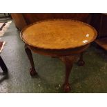 Mid-20th century circular walnut coffee table with pie-crust edge, raised on four claw and ball