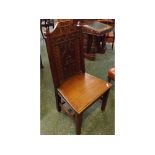 19th century hall chair with decorative carved panel back, armorial top rail on four square feet,