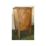 19th century bow fronted satinwood single door pot cupboard with shaped central lozenge supported on