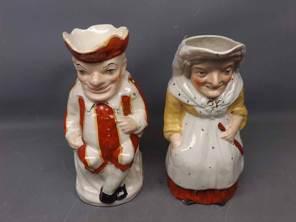 Two Staffordshire jugs modelled as Punch and Judy (a/f), 9 1/2 ins tall