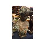 Composition bronzed bust of a young lady with a floral garland in her hair, raised on square plinth,