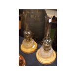 Pair of Victorian cut glass peg lamps, mounted on oak plinths with clear glass funnels, 16ins tall