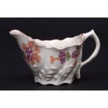 Lowestoft cream boat circa 1780 of Chelsea ewer shape the body moulded with flowers and decorated in