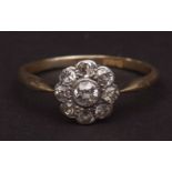 Precious metal and diamond cluster ring, the central brilliant cut diamond (0.15ct approx), bezel