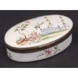 Enamelled oval snuff box, the hinged cover decorated with birds and trees with a blue fence to a