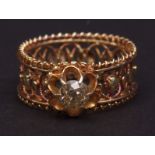 Yellow metal champagne diamond ring, the single cut diamond claw set and raised in a filigree