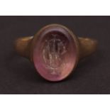 Yellow motor intaglio ring, the oval amethyst panel (10 x 7ins), engraved with a monogram, (