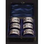 Late 19th century cased set of six electroplated napkin rings of cylindrical form with cast details,