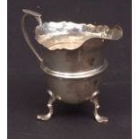 George V cream jug, with cut card rim, cast and applied handle and girdled body raised on three cast