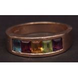 Modern yellow metal and multi coloured gem set ring, the wide plain polished band, pavi set with a