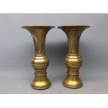 Pair of Oriental bronze trumpet vases with engraved detail, six character mark to base, 11ins tall