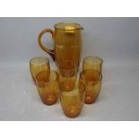 Early 20th century amber glass water set with a decorative reeded design, comprising a jug and six