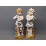 Pair of 19th century German bisque figures of a young girl holding a dove and a young boy holding