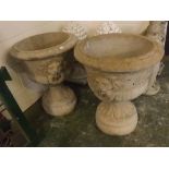 Pair of modern composition campana style urns with raised lion head handles, on circular plinths,