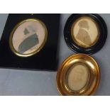 Two ebonised framed oval silhouettes of a lady wearing a bonnet and a gentleman, together with a