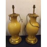 Pair of large 20th century yellow ground electric lamps with circular brass base and cast top,