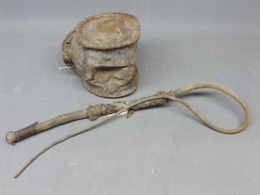 Eastern animal hide covered and stitched flask with a further hide and wooden rustic whip (2)