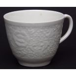 Worcester white coffee cup, circa 1770, finely moulded with a band of entwining peonies, 2 1/4 ins