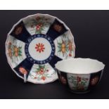 Worcester tea bowl and saucer of fluted shape, painted with panels of colours flowers, alternating