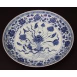 Chinese blue and white porcelain dish decorated in Ming style with a Lotus spray within scrolling