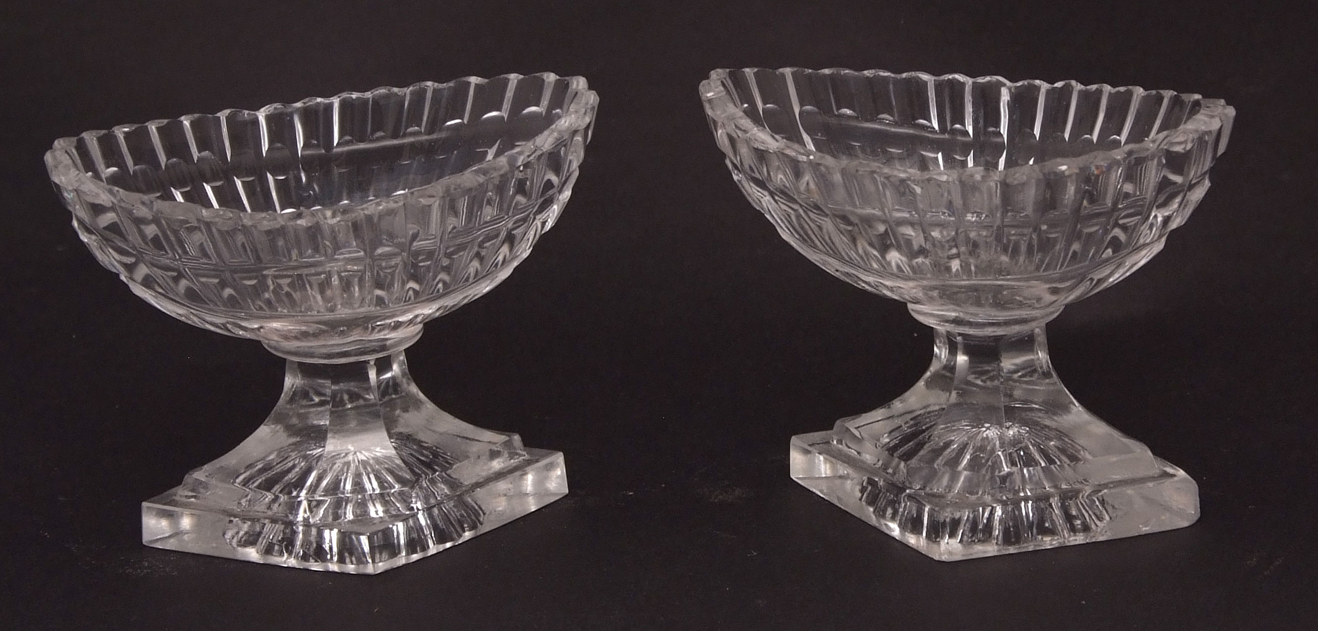 Pair of early 19th century faceted oval pedestal glass salts on diamond shaped bases, 3ins high