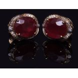 A pair of high grade yellow metal earrings, set to the centres with oval rubies, measuring