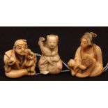 Three Japanese ivory netsuke, all early 20th century, a young boy seated holding a cockerel; a young