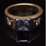 Modern mid-grade yellow metal sapphire and diamond ring, a light blue square emerald cut sapphire (