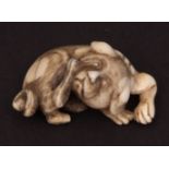 Japanese ivory netsuke of a dog scratching its chin with a hind leg, 19th century