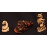 Three Japanese ivory netsuke, all early 20th century, a coiled snake and a Kirin and Samurai on