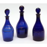 Three Bristol blue glass decanters, each with pear-shaped stoppers, comprising one for rum and two