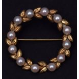 Yellow metal and cultured pearl brooch, a garland of leaves interspersed with 12 cultured pearls,