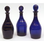 Three Bristol blue glass decanters, each with pear-shaped stoppers, comprising one for rum and two