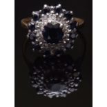 18ct gold sapphire and diamond cluster ring, the centre oval dark blue sapphire framed with a tier