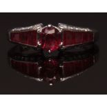 Modern precious metal ruby and diamond ring, the centre of oval cut faceted ruby (1.26ct approx),