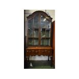 Mahogany cabinet on stand, arched top with gazed doors and two drawer base (composite), 33ins wide