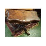19th century walnut fold-over card table with serpentine front and turned column on a carved