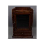 Mid-20th century oak smoker's stand with fitted interior with single glazed door over a carved