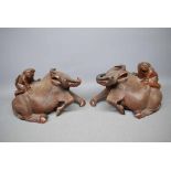 Pair of Chinese hardwood carved model of a single boy upon a recumbent buffalo, with glass eyes,