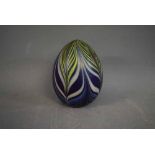 Indistinctly signed and dated 1976, an iridescent glass paperweight of ovoid form, in shades of