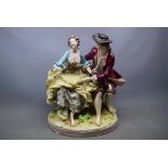 Hochst porcelain figure group of lovers seated, blue underglaze mark, 12ins tall (a/f)